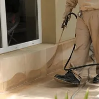 General pest control technician spraying exterior perimeter around a home in Fort Wayne, IN